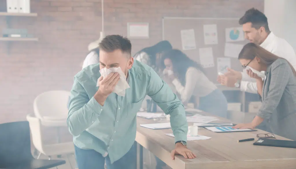 Personnes s'étouffant avec de la fumée dans un bureau